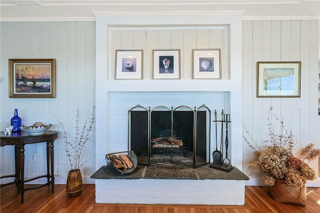 183 Twin Peninsula Ave, South Kingstown, RI 02879 - detailed view of wood finished floors, ornamental molding, a fireplace with raised hearth, and wooden walls