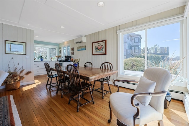 183 Twin Peninsula Ave, South Kingstown, RI 02879 - dining area featuring light wood-style flooring, a wall mounted AC, and a baseboard radiator
