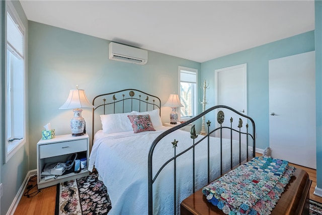 183 Twin Peninsula Ave, South Kingstown, RI 02879 - bedroom with a wall mounted air conditioner, wood finished floors, and baseboards