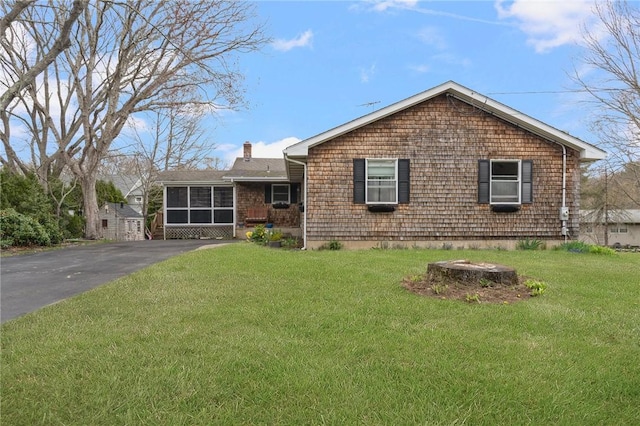 ranch-style house with a chimney and a front yard