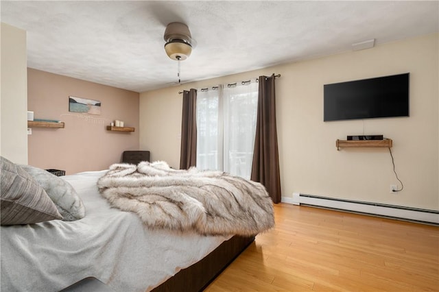 465 Camp Dixie Rd, Burrillville, RI 02859 - bedroom with a ceiling fan, baseboards, wood finished floors, and a baseboard radiator