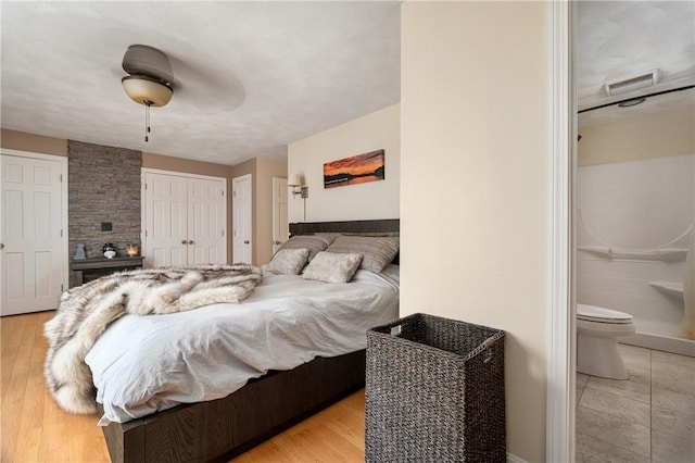 465 Camp Dixie Rd, Burrillville, RI 02859 - bedroom featuring connected bathroom, a ceiling fan, visible vents, and light wood-style flooring