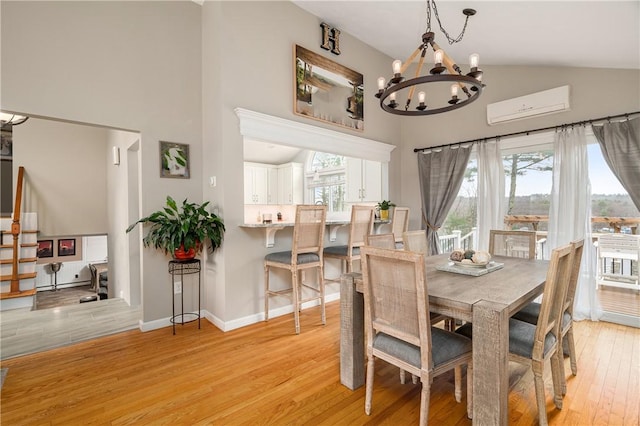 465 Camp Dixie Rd, Burrillville, RI 02859 - dining area with an inviting chandelier, high vaulted ceiling, baseboards, light wood-type flooring, and a wall mounted AC