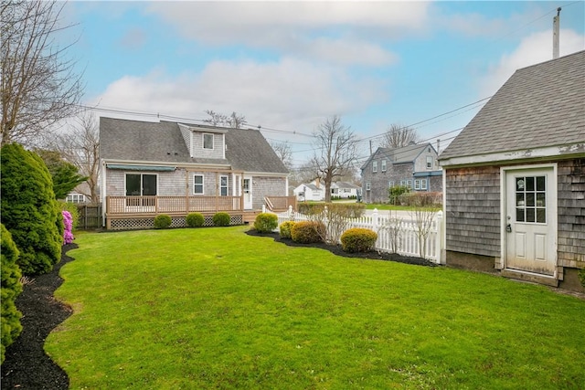 view of yard featuring a residential view, an outbuilding, fence, and a deck