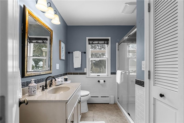bathroom with a shower stall, tile patterned floors, a baseboard heating unit, vanity, and toilet