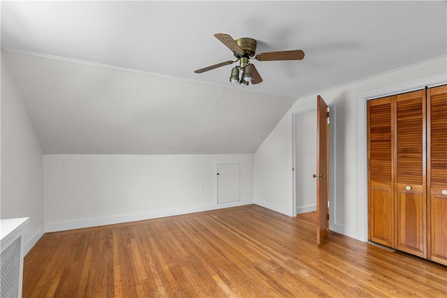 additional living space featuring ceiling fan, vaulted ceiling, baseboards, and light wood-type flooring