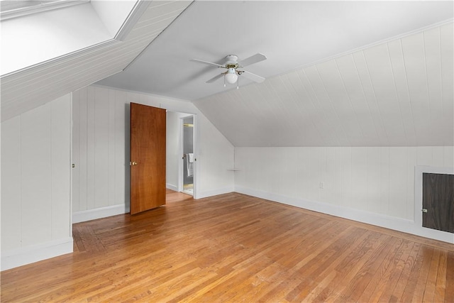 bonus room featuring ceiling fan, lofted ceiling, light wood-style floors, and baseboards
