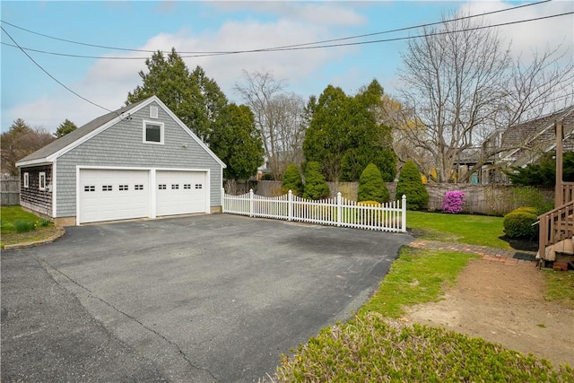detached garage featuring fence