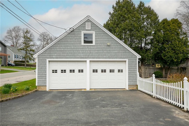 detached garage featuring fence