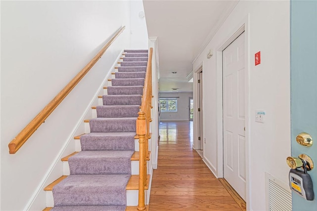 stairway with wood finished floors and visible vents