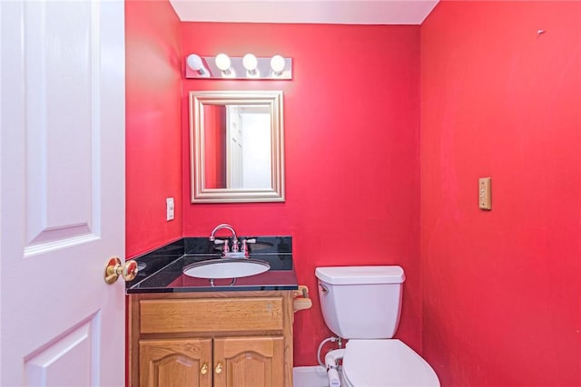 half bathroom with toilet and vanity