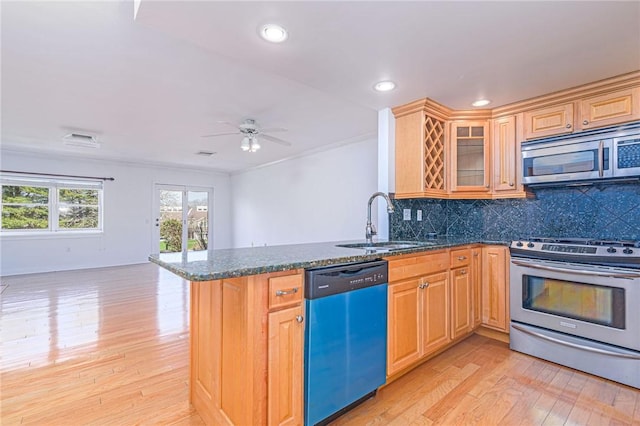 kitchen with stainless steel appliances, a sink, light wood-style floors, a peninsula, and open floor plan