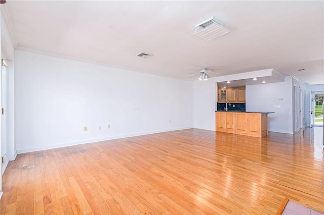 unfurnished living room with light wood-type flooring, baseboards, visible vents, ceiling fan, and ornamental molding