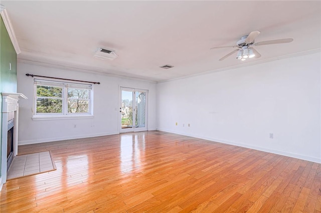 unfurnished room featuring light wood-type flooring, a fireplace with flush hearth, a ceiling fan, and crown molding