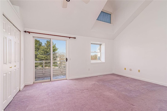 carpeted spare room with high vaulted ceiling, ceiling fan, and baseboards
