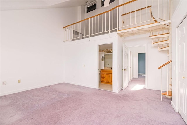 unfurnished living room featuring carpet floors and baseboards