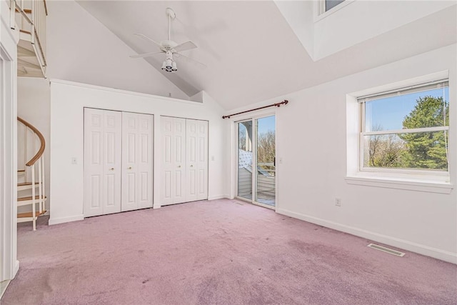 unfurnished bedroom with carpet floors, access to outside, multiple closets, and high vaulted ceiling