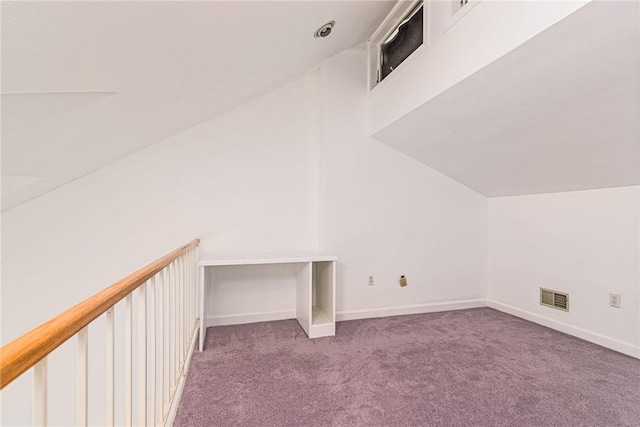 additional living space with baseboards, vaulted ceiling, visible vents, and carpet flooring