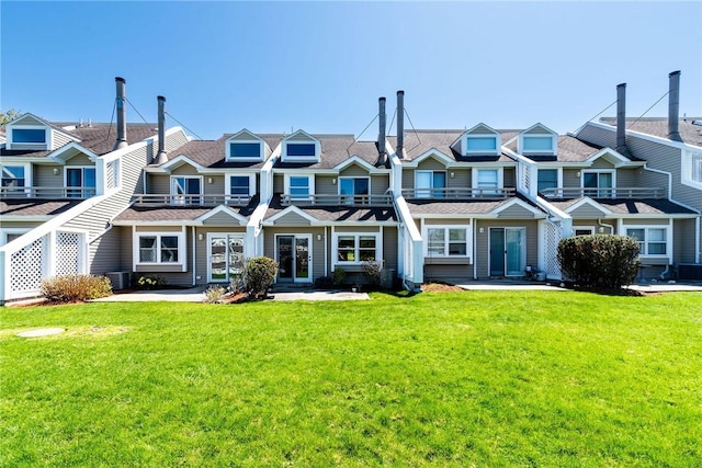 multi unit property with central AC, a residential view, and a front yard