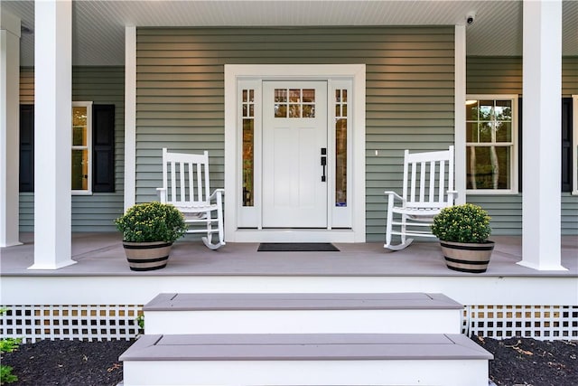 view of exterior entry featuring covered porch
