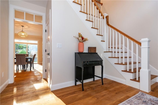 staircase with baseboards and wood finished floors