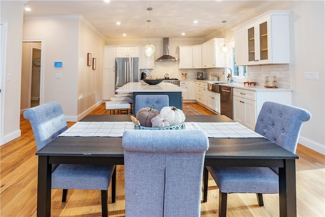 dining area with recessed lighting, light wood-style floors, baseboards, and ornamental molding