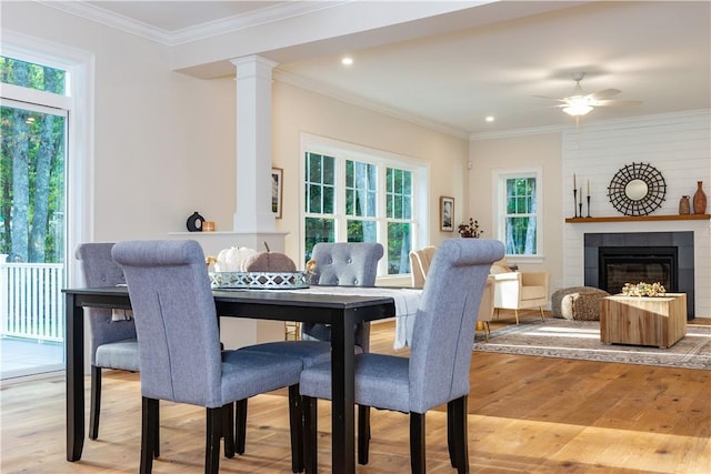 dining area featuring plenty of natural light, a ceiling fan, ornate columns, and light wood-type flooring