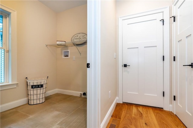 laundry area featuring baseboards, hookup for a washing machine, laundry area, and light wood-type flooring