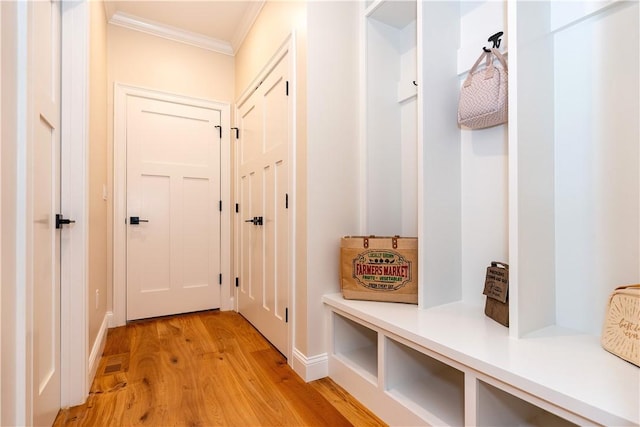 mudroom featuring light wood-style floors, baseboards, and ornamental molding