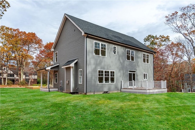 rear view of house with a wooden deck and a lawn