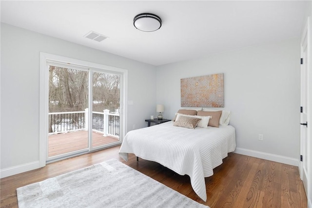bedroom featuring wood finished floors, visible vents, baseboards, and access to outside