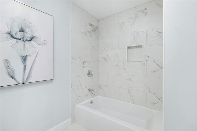 bathroom with marble finish floor, baseboards, and washtub / shower combination