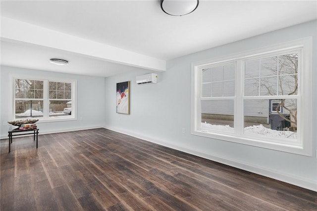 unfurnished room featuring dark wood finished floors, baseboards, and a wall unit AC