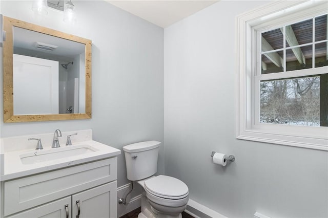 bathroom with visible vents, baseboards, vanity, and toilet