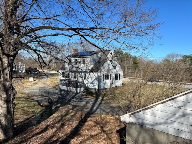 view of side of property with a wooden deck and a chimney