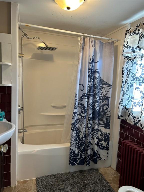 bathroom featuring radiator, visible vents, tile patterned flooring, and shower / bath combo