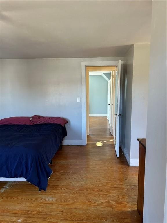 bedroom with wood finished floors and baseboards