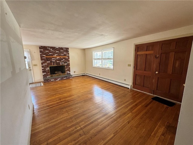 unfurnished living room with a baseboard radiator, a brick fireplace, and hardwood / wood-style flooring