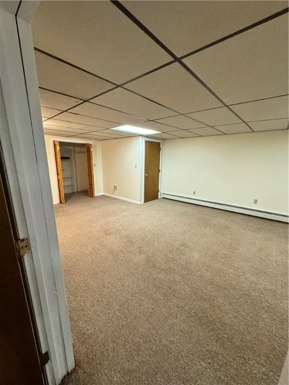 finished below grade area with carpet floors, a baseboard radiator, baseboards, and a drop ceiling