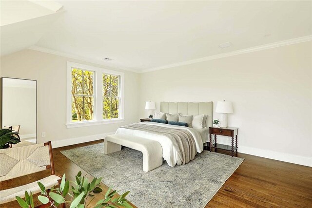 bedroom featuring ornamental molding, lofted ceiling, wood finished floors, and baseboards
