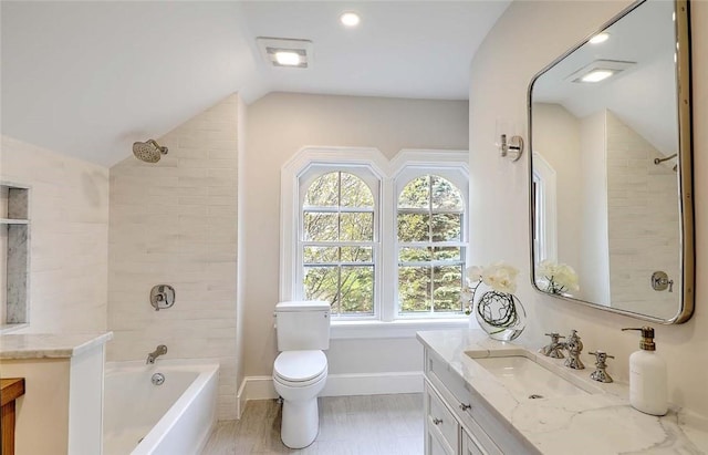 bathroom featuring lofted ceiling, toilet, washtub / shower combination, and vanity