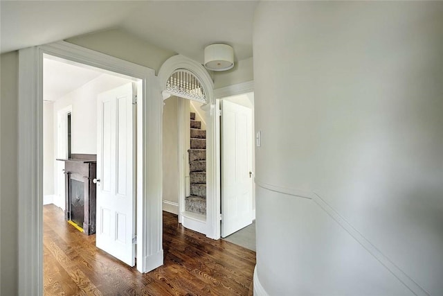 hall with vaulted ceiling, stairway, dark wood-style floors, and baseboards
