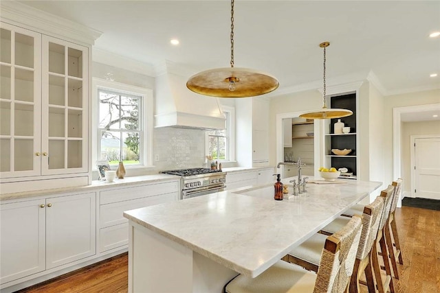 kitchen with a breakfast bar area, ornamental molding, and stainless steel stove