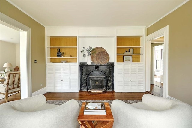 living room with crown molding, dark wood-style floors, built in features, and baseboards