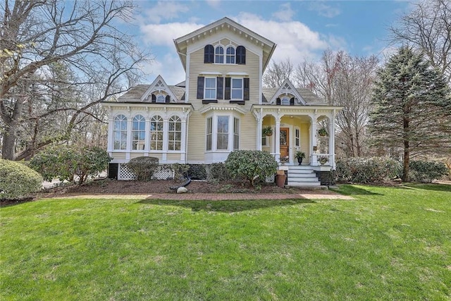 rear view of property with a porch and a lawn