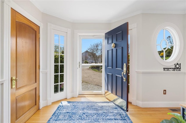 entrance foyer with light wood finished floors, baseboards, visible vents, and crown molding