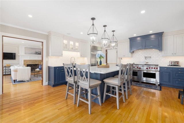 dining area featuring light wood-type flooring, a fireplace, a chandelier, and recessed lighting