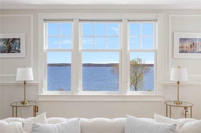 living area featuring a water view and ornamental molding