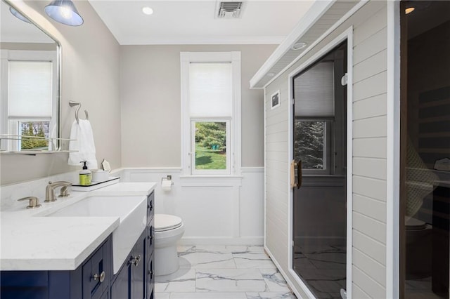 bathroom with marble finish floor, a wealth of natural light, a wainscoted wall, toilet, and visible vents