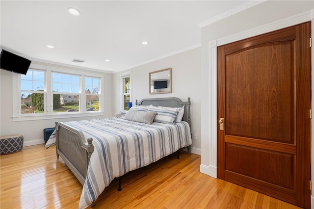 bedroom featuring recessed lighting, light wood finished floors, visible vents, ornamental molding, and baseboards